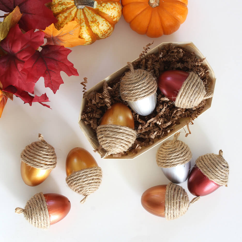 flat lay of metallic acorns with a twine cap styled next to a crinkle cut filled container