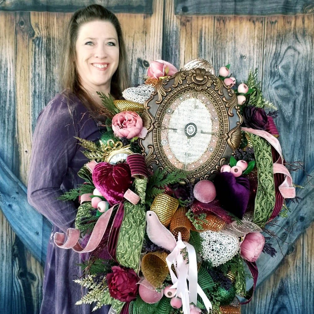 Michelle Reid of M&B Creations holding an ornate wreath made with Paper Mart ribbons and embellishments