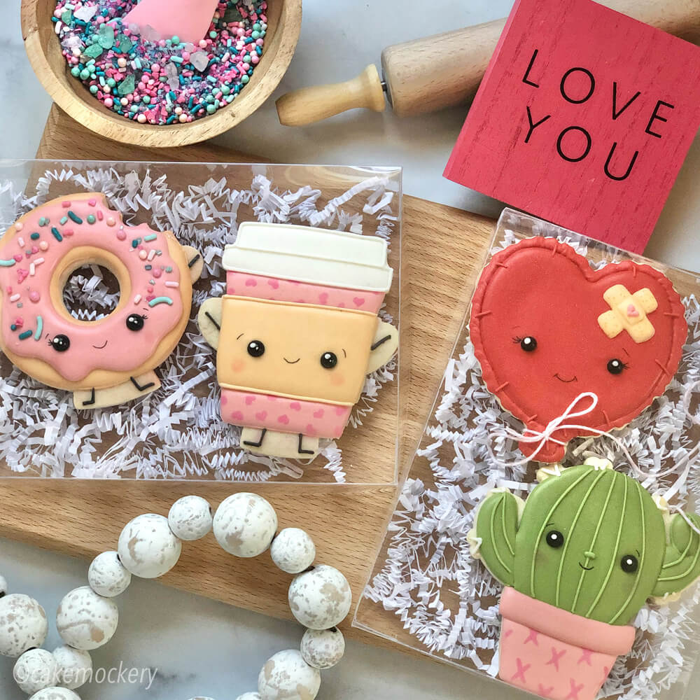 Decorated cookies made by Cake Mockery packaged in Paper Mart plastic boxes