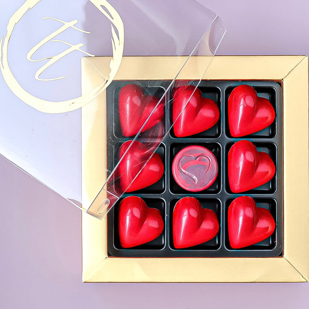 nine heart shaped truffles in a gold candy box