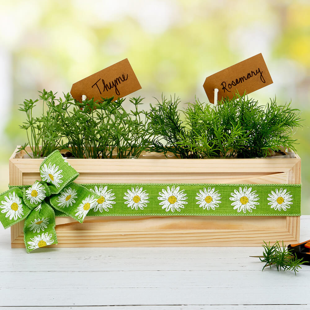 upcycled planter filled with herbs and decorated with paper mart ribbon