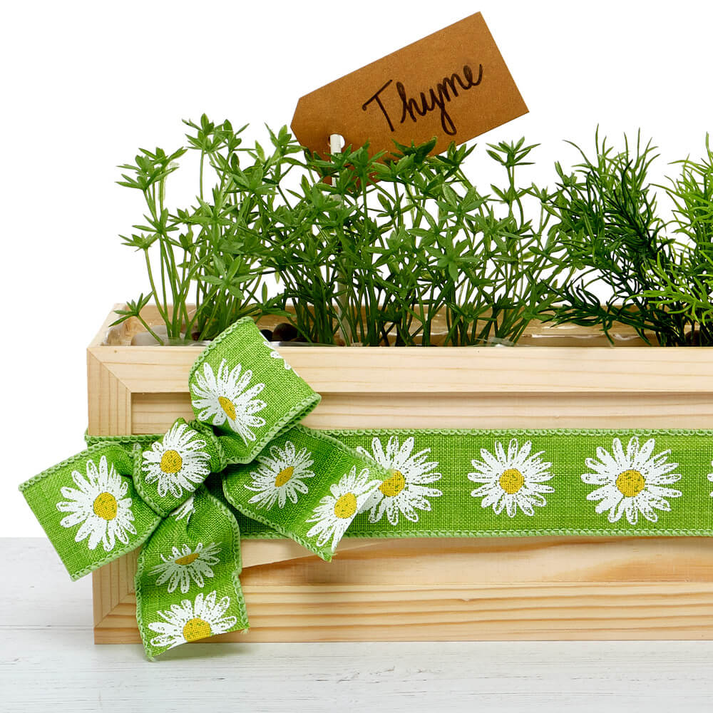 upcycled planter filled with herbs and decorated with paper mart ribbon