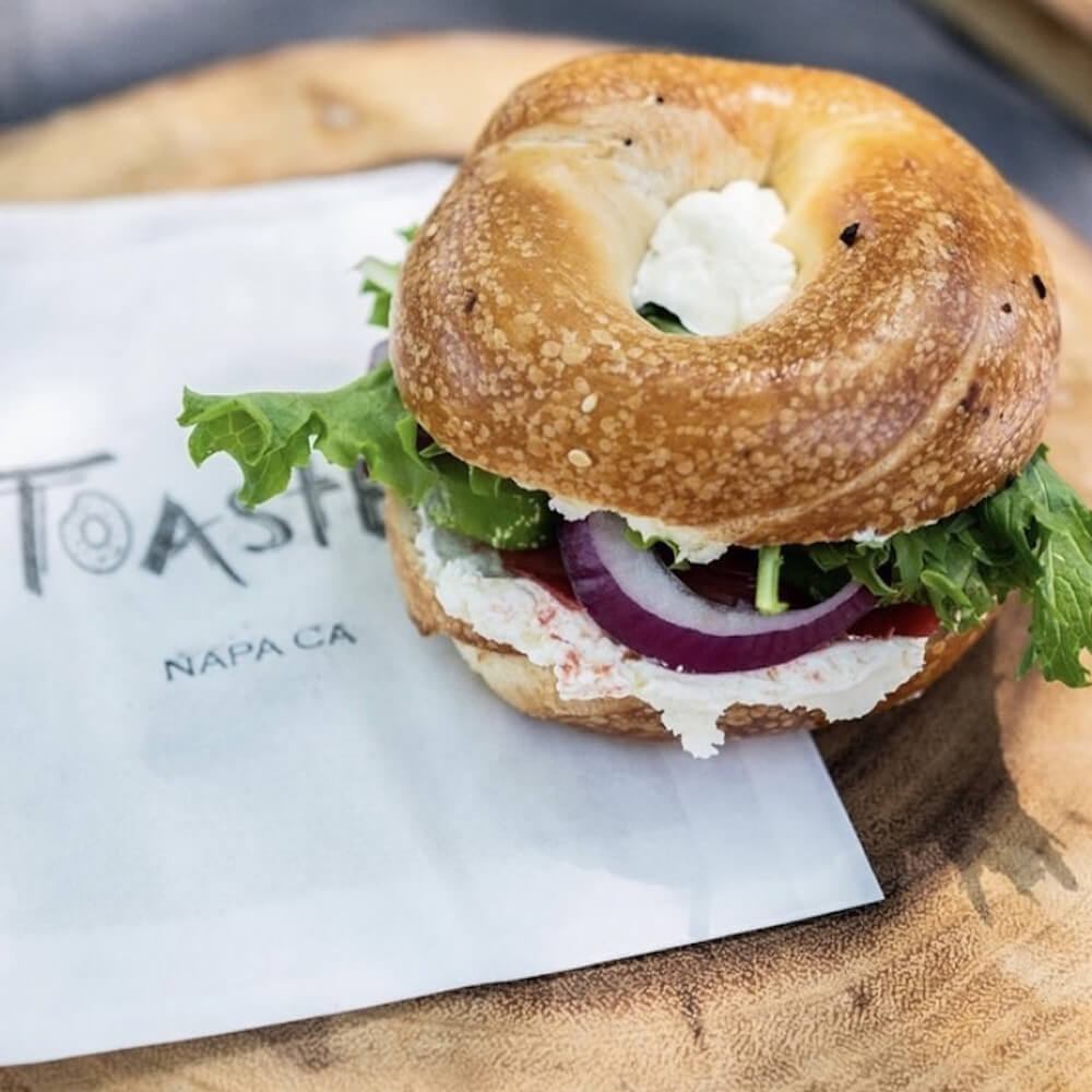 Toasted Napa bagel on top of a Paper Mart food bag